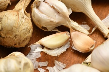 ripe garlic heads and cloves on a rustic wooden background, delicious and healthy food