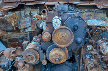 Fototapeta na wymiar Close-up of burnt rusty engine in russian military vehicle after combat strike