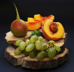 Sweet fruits on wood with bark in dark lighting. Shallow depth of field