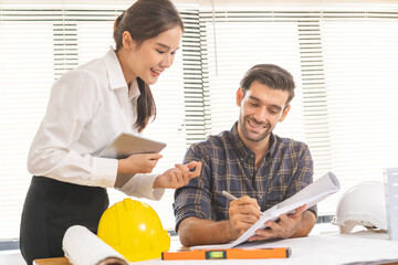 Construction of Engineer, architect businessman, woman making on blueprint of house building in office together, meeting plan working with partner team colleagues on blueprint, discussing design.