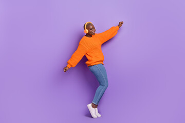 Fototapeta na wymiar Full length photo of cute young girl listen music weekend dressed stylish autumn orange knitwear jumper isolated on violet color background