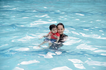 Mother hug her son in swimming pool