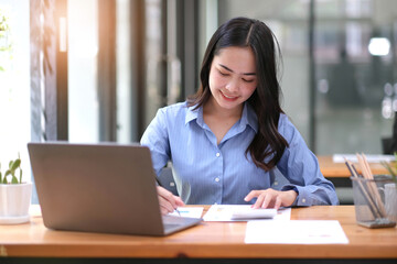 business woman hands using a calculator to check company finances and earnings and budget.