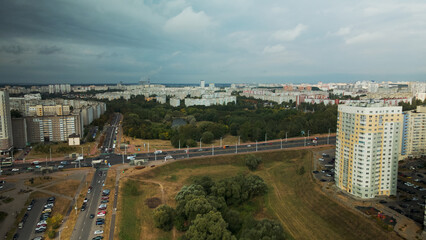 Obraz premium City with high-rise buildings. Park area in the foreground. Blue sky with clouds. Aerial photography.
