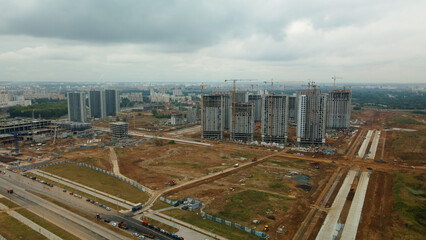 Construction site of a new city block. Construction of multi-storey buildings. Overcast weather. Aerial photography.