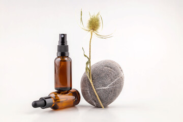 Fototapeta premium containers for cosmetics, stones and a sprig of prickly lint on a gray background