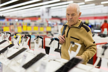 senor man pensioner buying modern smart watch in showroom of digital electronic goods store