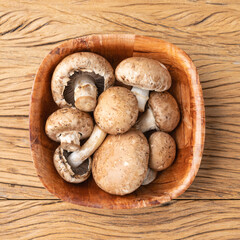 Portobello mushrooms in a bowl over wooden table