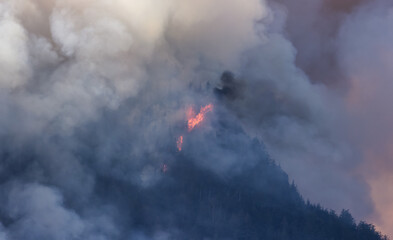 BC Forest Fire and Smoke over the mountain near Hope during a hot sunny summer day. British Columbia, Canada. Wildfire natural disaster