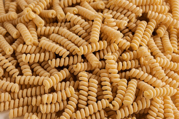 Gluten Free Cornmeal Pasta Wallpaper. Spiral Raw Macaroni from Corn and Rice flour rotating on Turntable. Close Up Top View. Uncooked Pasta Spinning. Full Frame. Food Background. Fusilli Bucati Corti.
