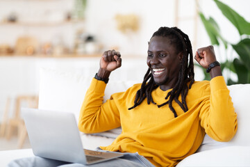 Online Win. Overjoyed Young Black Man Celebrating Success With Laptop At Home