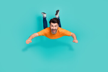 Full length photo of guy flying in air falling down virtual game isolated on cyan color background