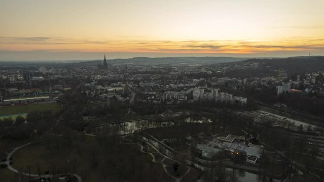 Aerial time lapse shot of the residential area Oststadt, park Friedrichsau and sport center. It&rsquo;s a brown winter evening with a colorful dusk