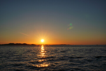 sunset near sea, no clouds. colorful sky and mirroring in water. small waves in ocean. rest on vacation, calm and relax