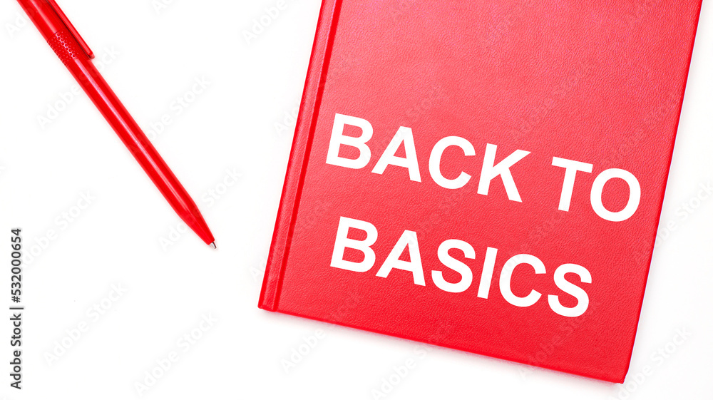 Aufkleber the text back to basics is written on a red notepad near a red pen on a white table in the office. b