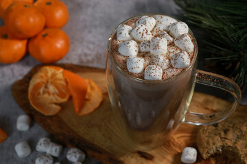 close up of mini marshmallows on hot chocolate in a glass mug, blurred lights background 