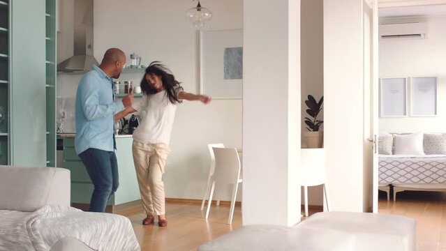 Dance, home and happy couple dancing to celebrate a new apartment, interior and real estate property together. Love, celebration and young wife with partner excited about moving into a rental house