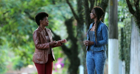 Candid African women talking outside exchanging ideas and conversation