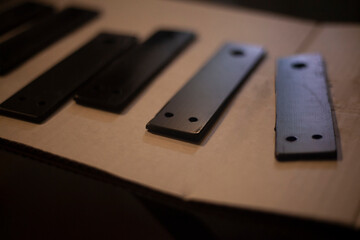 Steel blanks with holes. Metal painting. Details of workshop. Model made of metal. Rail for fastening structure.