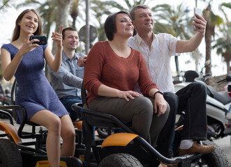 family of tourists enjoy a walk on the bike carriage