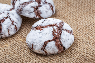 Cracked chocolate chip cookies sprinkled with white powder.