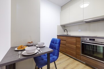 Stół w nowoczesnej stylowej kuchni w apartamencie z talerzami i ciasttkiem