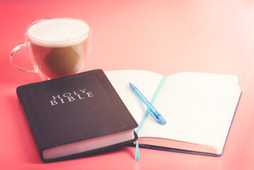The Holy Bible with a Notebook to Study on a Bright Pink Background