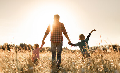 Father and his children walking in the field - obrazy, fototapety, plakaty
