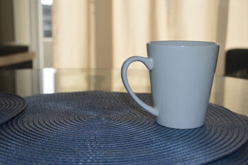 A WHITE CUP ON A KITCHEN TABLE