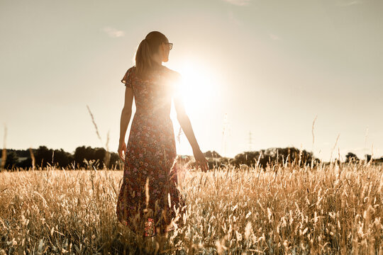 woman walking in the field early morning enjoying peace in nature 