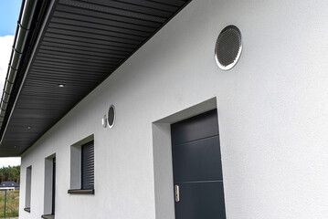 Air intake and exhaust in the wall of a single family house for mechanical ventilation with heat...