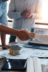 Architect and engineer work together and shaking hands to welcome home design projects to work in the same way and work together as a team.
