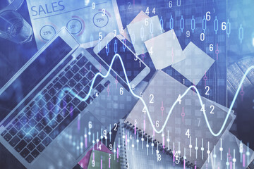 Financial market graph and top view computer on the desktop background. Multi exposure. Investment concept.