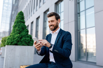 Businessman at conference outdoor. Happy confident attractive young caucasian male with beard in suit