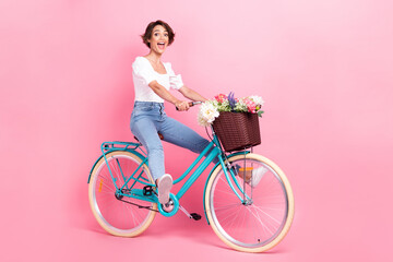 Full length photo of excited funky lady wear white crop top riding bike fast isolated pink color...