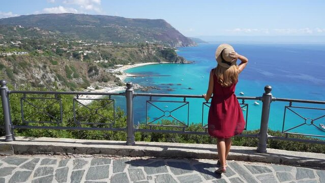 Traveling in Italy. Panoramic view of elegant woman with hat in Capo Vaticano in the Coast of the Gods, Calabria, Italy.