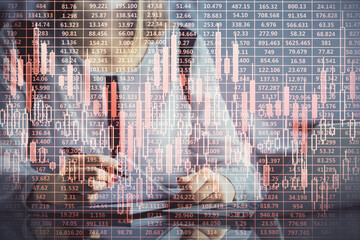 Double exposure of businesswoman hands typing on computer and financial graph hologram drawing....