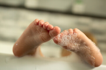 Children's feet in foam in the bath