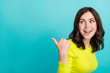 Photo of young attractive funny surprised woman directing finger empty space look discount clothes...