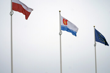 The flags of Poland, the European Union and Gdynia are flying in the air.    