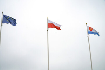 The flags of Poland, the European Union and Gdynia are flying in the air.    
