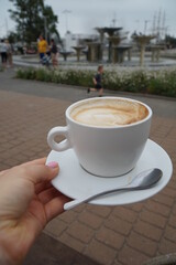 A cup of coffee on the background of the Baltic sea embankment.  