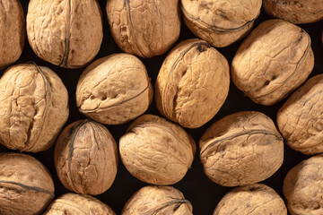 Heap of ripe walnuts on the market close-up. View from above