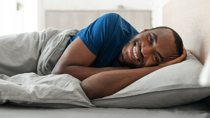 Black Guy Posing Lying In Bed Smiling Resting At Home