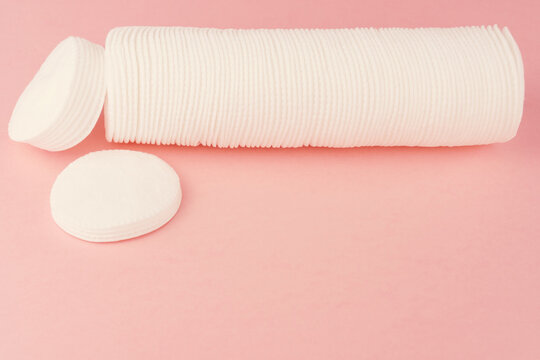 Group of cotton pads on pink background.
