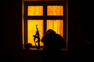 Conceptual photo of war between Russia and Ukraine. Ukraine and Russia flags on windowsill at night. Old creepy room with window.