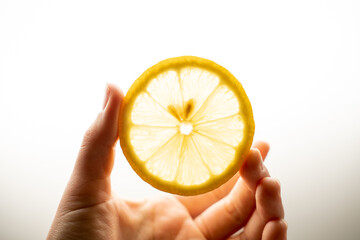 round slice of lemon in hand