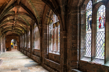 view of the cloister hallway in the courtyard of the historic Chester Cathedral with stained glass...