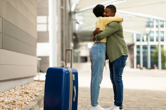 Black Husband Meeting Wife In Airport, Hugging Standing Indoor