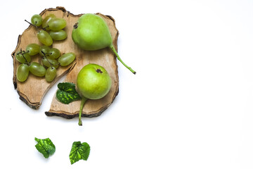 A bunch of grapes and wild pears on a wooden board on a white background. Close-up